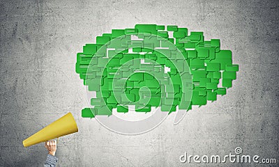 Hand of woman holding green paper trumpet and speech cloud coming out Stock Photo