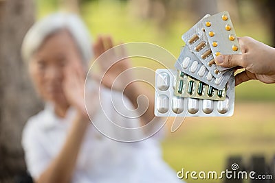 Hand of woman holding medicine tablets,capsules,show lots of medication,old elderly on blurred background,senior people raise Stock Photo