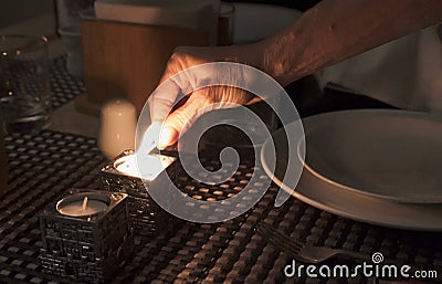 Hand of woman lighting candles for popular Shabbat meal Stock Photo