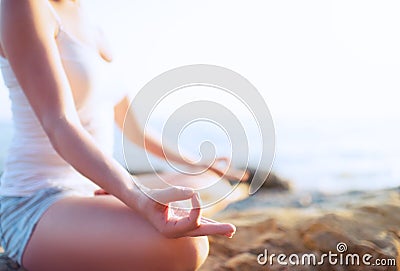 Hand of woman meditating in a yoga pose on beach Stock Photo