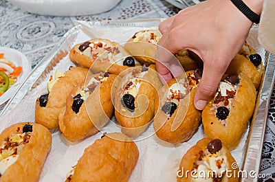 Hand woman takes a donut with eggs, olives and capsicum Stock Photo