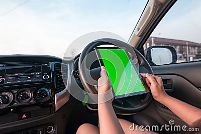 Hand of woman using tablet with blank green screen monitor in SUV car Stock Photo