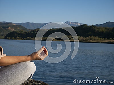 Hand woman yoga and lotus pose meditation and relax in the mountan lake. Healthy and Zen Concept Close up Stock Photo
