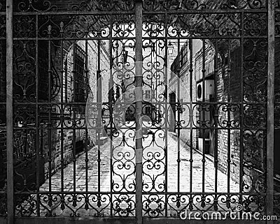 Hand-worked wrought iron gate with internal courtyard of an old Stock Photo