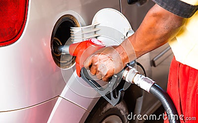 Hand of worker man refuelling a car at the petrol station. Concept photo for use of fossil fuels gasoline, diesel in combustion Stock Photo