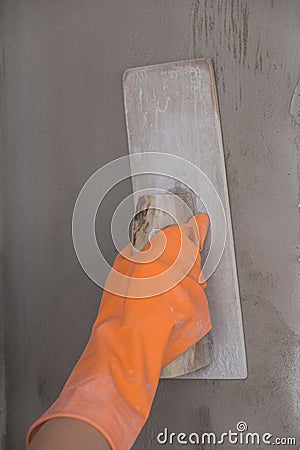 Hand of worker use trowel plastering concrete at wall Stock Photo