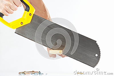 Hand of a workman cutting a wooden block with a handsaw Stock Photo