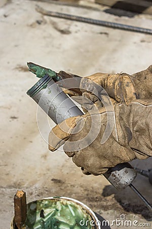 Hand of a workman filling grease gun Stock Photo