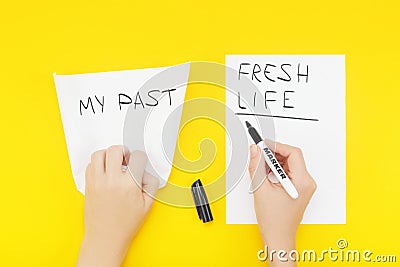 Hand wrinkles a piece of paper with the phrase: My past, and writes on a blank sheet of paper: Fresh life Stock Photo