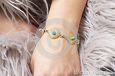 hand wrist wearing brass golden bracelet with turqoise mineral stone Stock Photo