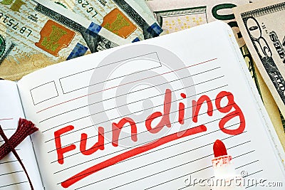 Hand is writing Funding in a note. Stock Photo