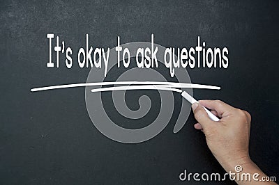 Hand writing It is okay to ask questions affirmation on black board. Affirmation concept Stock Photo