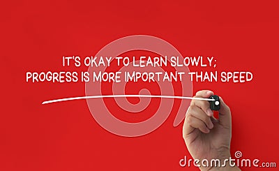 Hand writing It is okay to learn slowly affirmation on red cover background. Affirmation concept. Stock Photo