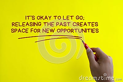 Hand writing It is okay to let go affirmation on yellow cover background. Affirmation concept. Stock Photo