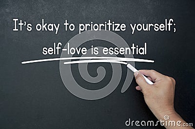 Hand writing It is okay to prioritize yourself affirmation on black board. Affirmation concept. Stock Photo