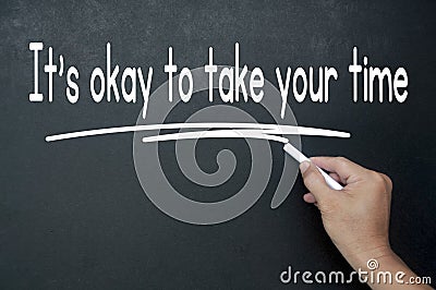 Hand writing It is okay to take your time affirmation on black board. Affirmation concept Stock Photo