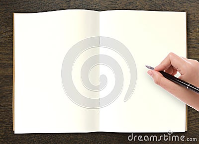 Hand writing in open book on table Stock Photo