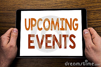 Hand writing text caption Upcoming Events. Business concept for Appointment Agenda List Written on tablet laptop, wooden backgroun Stock Photo