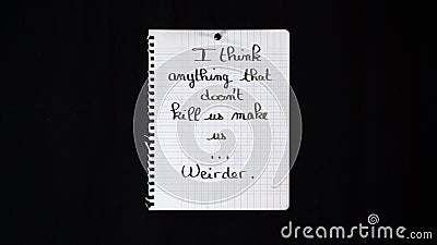 Hand written message on a ripped notebook sheet: I think anything that doesn`t kill us make us...Weirder Stock Photo