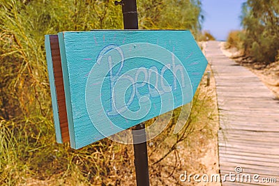 Hand written wooden sign pointing to the beach Stock Photo