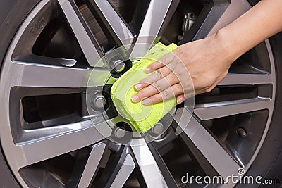 Hand with yellow microfiber cloth cleaning big max car.