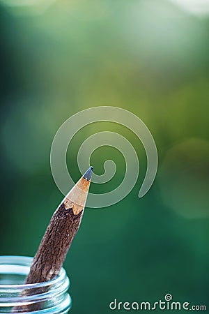 Handcraft pencil made of wood in glass bottle with smooth blur green garden background Stock Photo