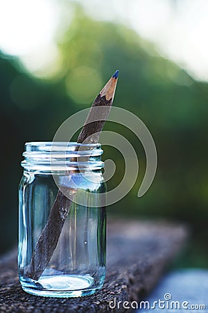 Handcraft pencil made of wood in glass bottle with smooth blur green garden background Stock Photo