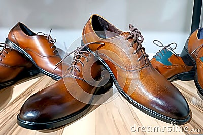 Handcrafted brown leather men shoes on the display shelves in the shoe shop. Stock Photo