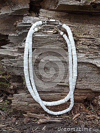 Handcrafted mother of pearl necklaces from polished pieces on natural wooden background Stock Photo