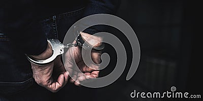 Handcuffed arrested man behind prison bars. copy space Stock Photo