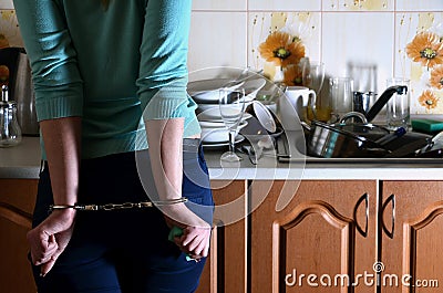 Fragment of the handcuffed female body at the kitchen counter, f Stock Photo