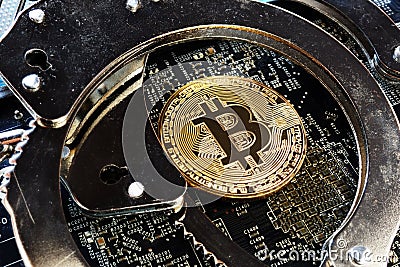 Handcuffs and Bitcoin coin. Crime with cryptocurrency. Stock Photo