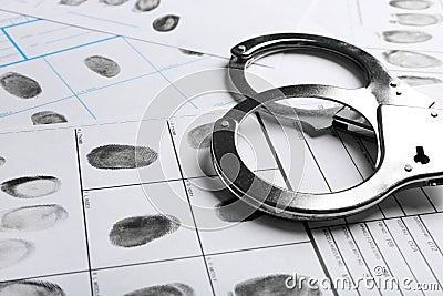 Handcuffs and fingerprint record sheets. Criminal investigation Stock Photo