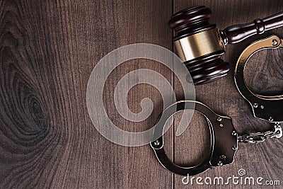 Handcuffs and judge gavel on wooden background Stock Photo