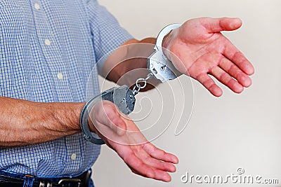 Handcuffs on the wrists of the detained man Stock Photo