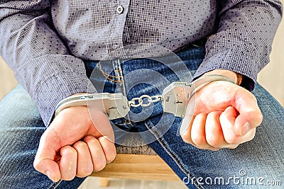 Handcuffs on the wrists of the detained man Stock Photo