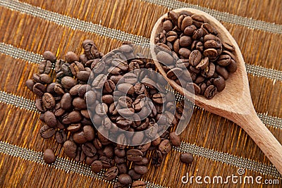 Handful coffee beans and coffee beans in a wooden spoon Stock Photo