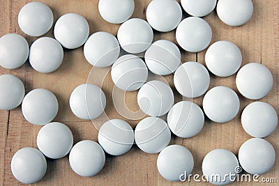 Handful of many white tablets closeup on wood background Stock Photo