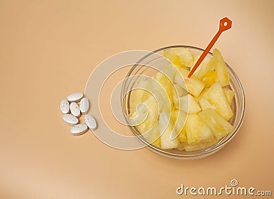 Handful pilule and cup filled with pineapple slices Stock Photo