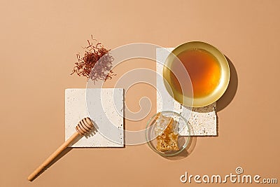 A handful of saffrons, honey dripping, golden bowl of honey and a glass petri dish of beeswax Stock Photo