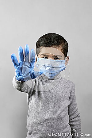 Handgesturing stop - 7 years old boy in medical face mask and gloves Stock Photo