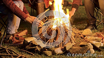 Handheld footage of man making camp fire for his friends in a cold night Stock Photo