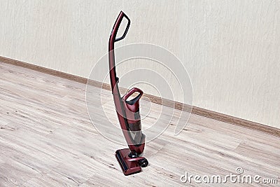 Upright red vacuum cleaner in empty room Stock Photo
