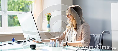 Handicapped Businesswoman Using Desktop Computer Stock Photo