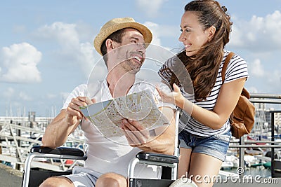 Handicapped man in wheelchair and girlfriend on holidays Stock Photo