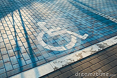 Handicapped parking bay. Reserved parking sign for disabled spaces disabled blue parking sign painted on dark asphalt Stock Photo