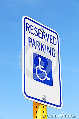 A handicapped parking sign against a blue sky. Stock Photo