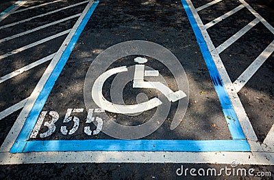 Handicapped sign parking spot, disabled parking permit sign painted on road Stock Photo