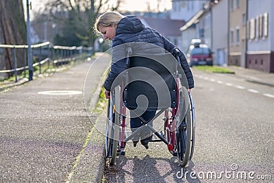 Handicapped woman using her wheelchair in a street Stock Photo