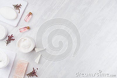 Handicraft natural cosmetics - white cream, soap, clay, rose oil, towel, pink flowers and bath accessories on soft light white. Stock Photo